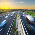 Fliessender Autobahnverkehr mit Bewegungsunschärfe bei Sonnenuntergang